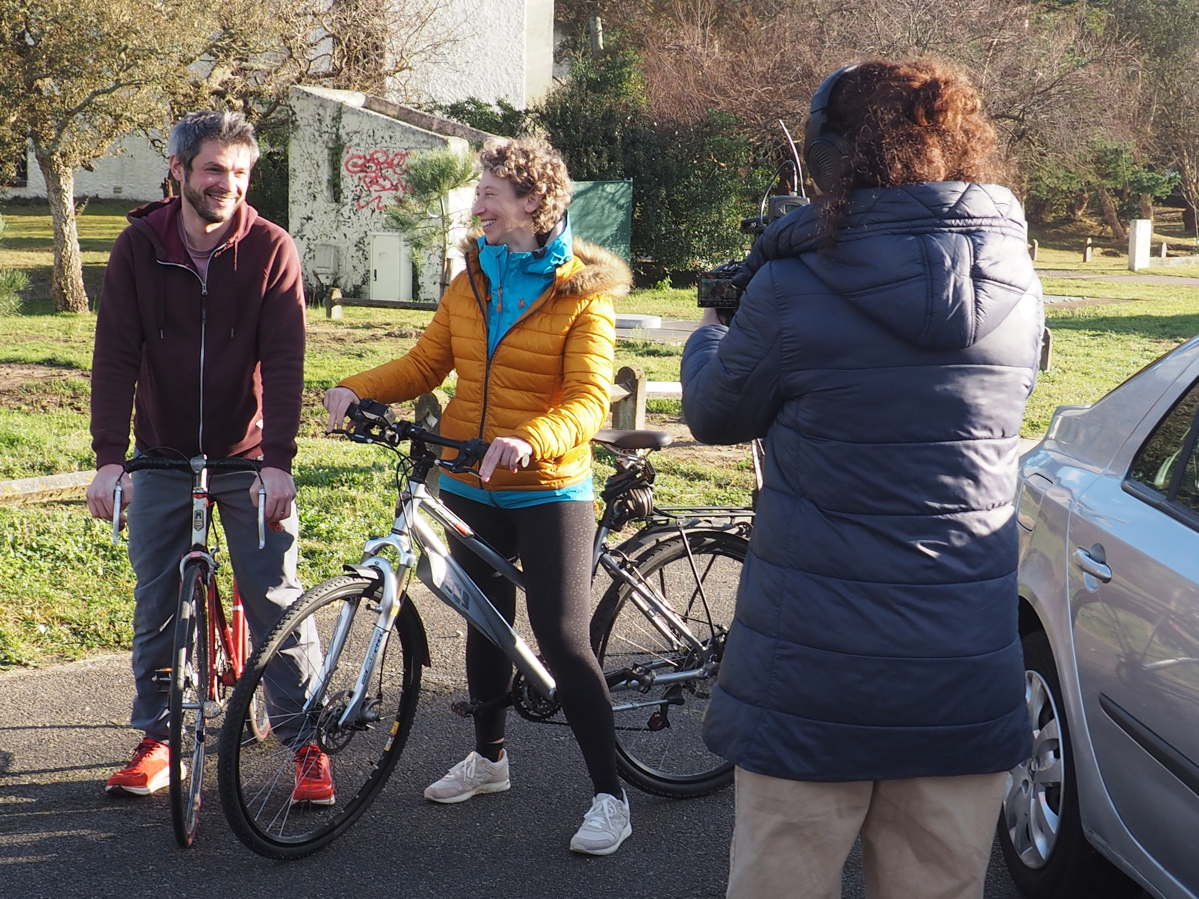 Une femme (la présidente de TcheckeTaMoelle) et un homme en vélo avec une journaliste 